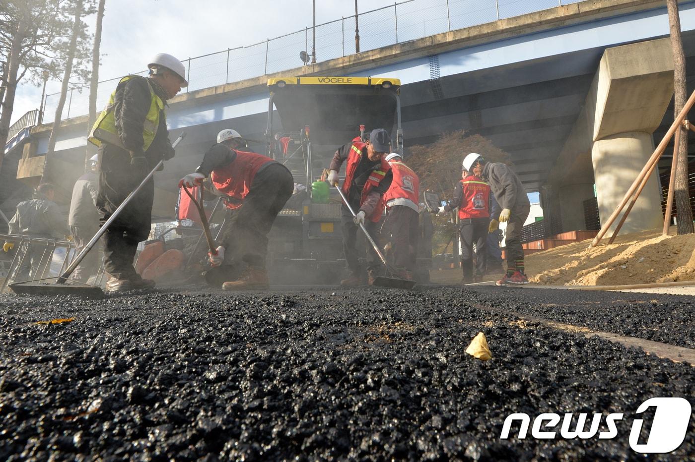 본문 이미지 - 인부들이 아스팔트 도로 포장 작업을 하고 있다.  ⓒ 뉴스1 최창호 기자