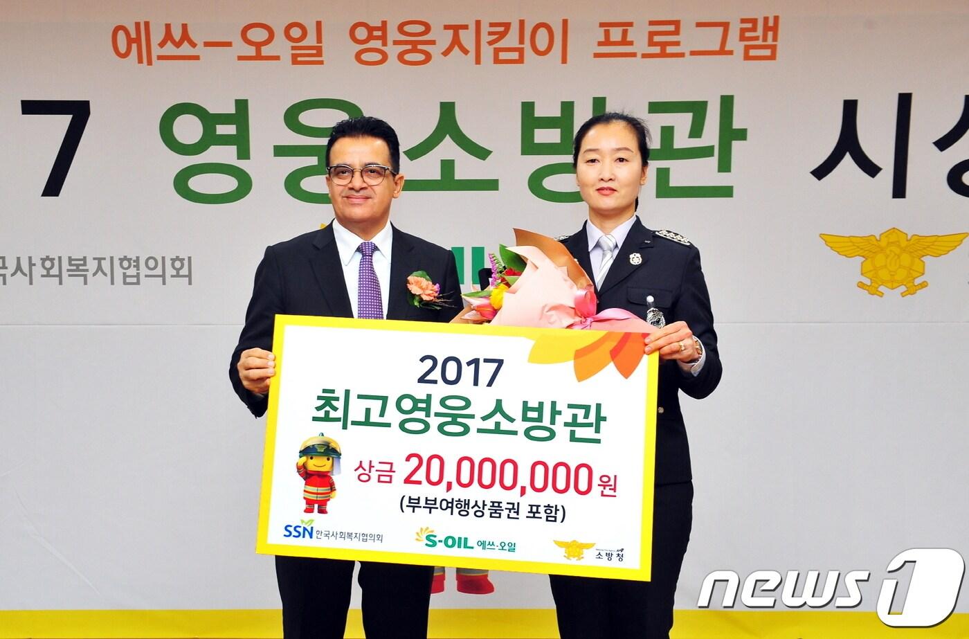 오스만 알 감디 CEO(왼쪽)가 최고영웅소방관으로 선정된 김미희 소방장(충남 보령소방서)에게 상금을 전달하고 기념촬영을 하고 있다. ⓒ News1