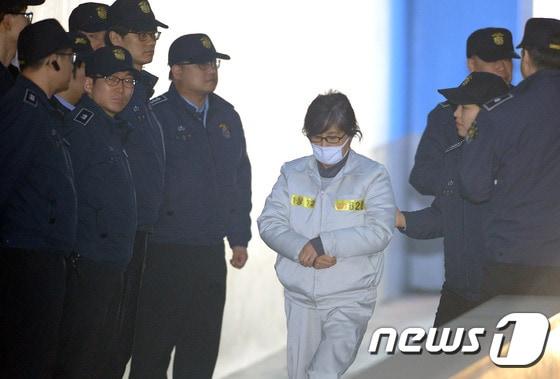 본문 이미지 - 국정농단 혐의로 구속 기소된 최순실 씨가 서초구 서울중앙지방법원에서 열린 공판에 출석하기 위해 호송차에서 내려 법정으로 향하고 있다. 2017.2.13 ⓒ 뉴스1 박정호 기자