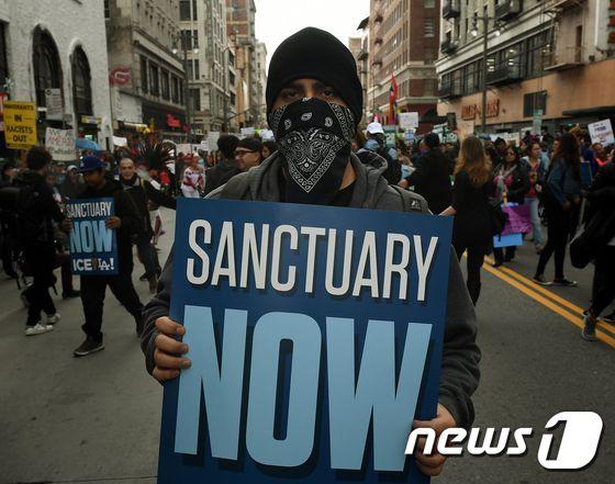 본문 이미지 - 도널드 트럼프 대통령 1기 임기 당시 캘리포니아 주 로스앤젤레스에서 시위대들이 대통령의 이민정책을 반대하며 “이민자들이 미국을 위대하게 만든다” 행진을 하고 있다. <자료 사진> ⓒ AFP=뉴스1 ⓒ News1 우동명 기자