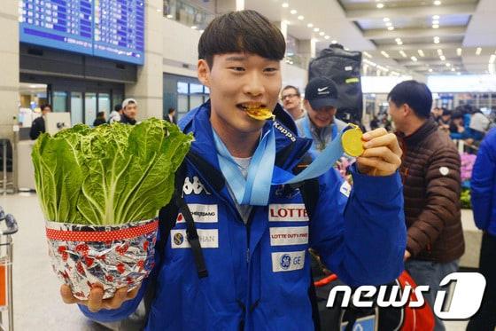 본문 이미지 - ‘2017 삿포로 동계아시안게임’ 스노보드에서 2관왕을 차지한 이상호가 21일 인천국제공항에서 금메달과 배추를 들고 포즈를 취하고 있다. 이상호는 스노보드 남자 회전과 대회전 모두 1위를 차지해 이번 대회 첫 2관왕에 올랐다. 2017.2.21/뉴스1 ⓒ News1 황기선 기자