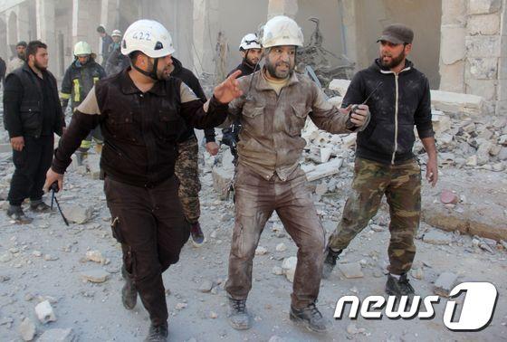 본문 이미지 - 하얀 헬멧을 쓰고 활동하는 시리아 자율 민방위조직 대원들이 25일 이들리브 외곽에서 구조 작업을 진행 중이다. ⓒ AFP=뉴스1