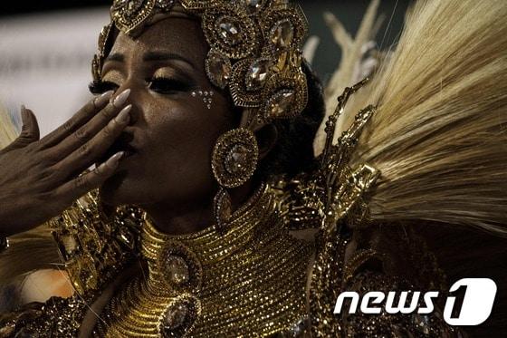 본문 이미지 - 브라질 리우데자네이루 삼보드롬에서 리우 카니발 둘째날인 27일(현지시간) 밤 '우니도스 다 티후카' 삼바 스쿨 소속의 댄서가 손에 입을 맞추고 있다 ⓒ AFP=뉴스1 ⓒ News1 최종일 기자