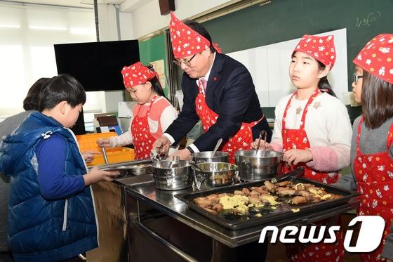 본문 이미지 - 김석준 부산시교육감이 3일 오전 부산 연제구에 있는 연미초등학교를 방문해 앞치마와 두건을 직접 쓰고 학생들에게 급식을 나눠주고 있다.(부산시교육청 제공)ⓒ News1
