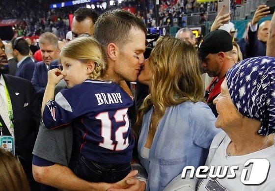 본문 이미지 - 뉴잉글랜드 패트리어츠의 톰 브래디가 텍사스 주 휴스턴의 NRG스타디움에서 열린 애틀랜타 팰컨스와의 제51회 NFL 챔피언 결정전 슈퍼볼에서 우승을 한 뒤 아내 지젤 번천의 축하키스를 받고 있다.  ⓒ AFP=뉴스1 ⓒ News1 우동명 