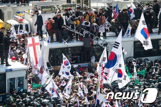 본문 이미지 - 10일 서울 종로구 안국역사거리에서 열린 대통령탄핵기각을위한국민총궐기운동본부&#40;탄기국&#41; 주최 태극기집회에 참석한 시민들이 박근혜 전 대통령의 탄핵이 인용되자 경찰 차벽을 넘어 헌법재판소 진입을 시도하고 있다. 2017.3.10/뉴스1 ⓒ News1 유승관 기자