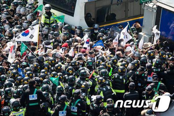 본문 이미지 - 10일 서울 종로구 안국역사거리에서 열린 대통령탄핵기각을위한국민총궐기운동본부&#40;탄기국&#41; 주최 태극기집회에 참석한 시민들이 박근혜 전 대통령의 탄핵이 인용되자 경찰 차벽을 넘어 헌법재판소 진입을 시도하고 있다. 2017.3.10/뉴스1 ⓒ News1 유승관 기자