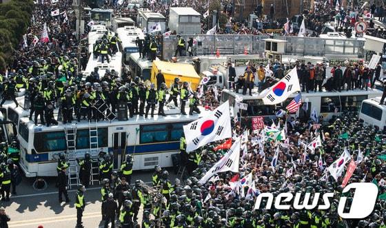 본문 이미지 - 10일 서울 종로구 안국역사거리에서 열린 대통령탄핵기각을위한국민총궐기운동본부(탄기국) 주최 태극기집회에 참석한 시민들이 탄핵이 인용되자 경찰 차벽을 넘어 헌법재판소 진입을 시도하고 있다.  2017.3.10/뉴스1 ⓒ News1 유승관 기자