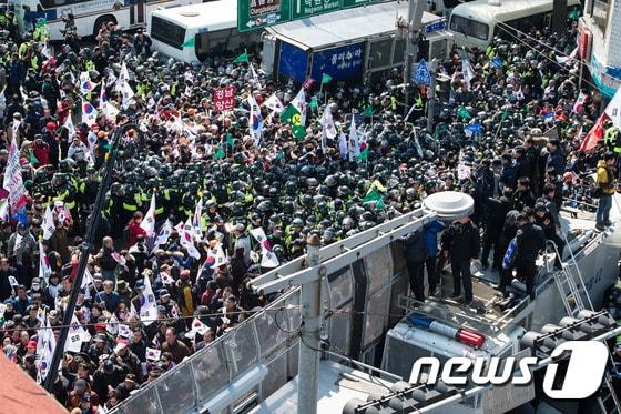 본문 이미지 - 10일 서울 종로구 안국역사거리에서 열린 대통령탄핵기각을위한국민총궐기운동본부(탄기국) 주최 태극기집회에 참석한 시민들이 박근혜  대통령의 탄핵이 인용되자 경찰 차벽을 넘어 헌법재판소 진입을 시도하고 있다.  2017.3.10/뉴스1 ⓒ News1 유승관 기자