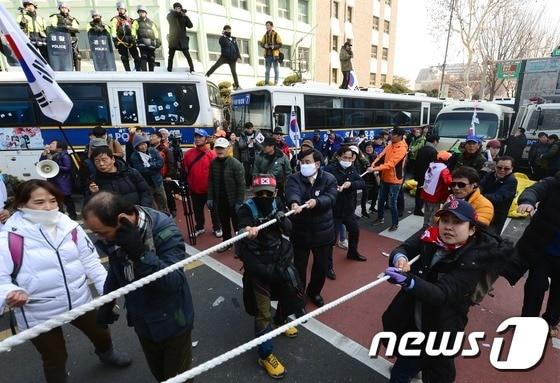 본문 이미지 - 2017년 3월 10일 오후 서울 종로구 안국역 4번 출구에서 탄핵반대집회 시위대가 경찰과 대치하고 있다. 이날 헌법재판소 재판관들이 만장일치로 탄핵인용 결정을 하자 과격해진 시위대로 안국역 주변 탄핵반대집회가 열린 도로는 아수라장이 됐다. 2017.3.10/뉴스1 ⓒ News1 DB