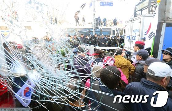 본문 이미지 - 10일 오후 서울 종로구 안국역 4번 출구에서 경찰버스의 유리창이 깨져 있다. 이날 헌법재판소 재판관들이 만장일치로 탄핵인용 결정을 하자 과격해진 시위대로 안국역 주변 탄핵반대집회가 열린 도로는 아수라장이 됐다. 2017.3.10/뉴스1 ⓒ News1 최현규 기자