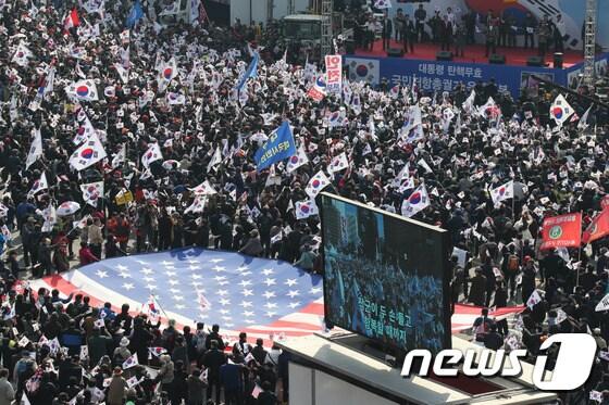 본문 이미지 - 박근혜 대통령 탄핵무효 국민저항 총궐기 국민대회가 11일 오후 서울 시청 앞 서울광장에서 열렸다. 대형화면에 군가 가사가 보이고 있다. 2017.03.11/뉴스1 ⓒ News1 &#40;사진공동취재단&#41;