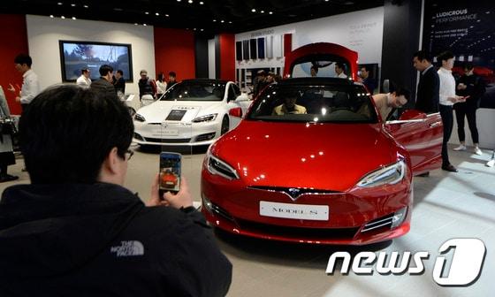 본문 이미지 - 경기 스타필드 하남에 오픈한 미국 전기차업체 테슬라 국내 1호 매장에서 고객들이 모델S 90D 전시차량을 둘러보고 있다. 2017.3.15/뉴스1 ⓒ News1 안은나 기자