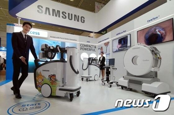 본문 이미지 - 지난 3월16일 서울 강남구 삼성동 코엑스에서 열린 '제33회 국제의료기기·병원설비 전시회(KIMES 2017)' 삼성 전시존에서 모델들이 가벼워지고 몸체도 슬림해져 이동성이 더욱 강화된 디지털 엑스레이 'GM85'와 현장 진단에 적합한 랩탑형 초음파 진단기기 'HM70A with Plus', 구급차에 탑재되어 뇌졸중 대응 시간을 단축시켜주는 이동형 CT 'CereTom&reg;'을 소개하고 있다. (삼성전자 제공) 2017.3.16/뉴스1