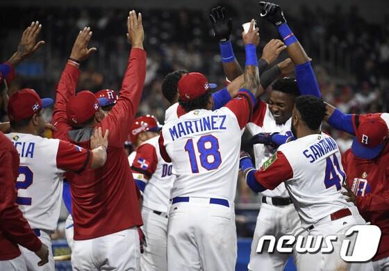 본문 이미지 - 도미니카공화국 그레고리 폴랑코가 17일(한국시간) 베네수엘라와의 WBC 경기에서 솔로 홈런을 터트린 뒤 팀 동료들의 환영을 받고 있다. ⓒ AFP=News1