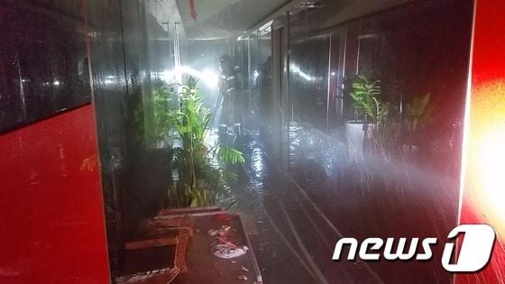 본문 이미지 - 19일 오전 5시께 부산 연제구에 있는 한 노래방에서 불이나 소방대원들이 불길을 진압하기 위해 천장을 부수고  물을 주입하고 있다. (부산소방본부 제공)ⓒ News1