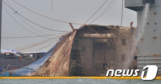 본문 이미지 - 24일 오전 세월호 침몰 해역인 전남 진도군 동거차도 앞바다에서 중국 인양업체인 상하이샐비지사 소속 인양 선원들이 세월호 선체에 올라 인양작업을 진행하고 있다. 문제가 됐던 세월호 선미램프 제거 작업은 완료됐다. 2017.3.24/뉴스1 ⓒ News1 김명섭 기자