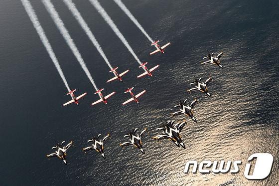 본문 이미지 - 공군 특수비행팀 ‘블랙이글’의 T-50B 항공기가 지난 24일부터 25일까지 말레이시아에서 열린 ‘랑카위 국제 해양항공전 17(LIMA 2017)’ 퍼블릭데이 행사에서 인도네시아 주피터 팀의 KT-1 항공기와 우정비행을 하고 있다. (공군본부 제공) 2017.3.26/뉴스1