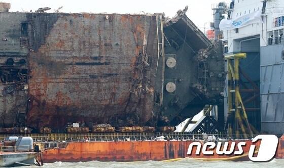 본문 이미지 - 27일 전남 진도 동거차도 앞 바다의 반잠수선 위에 올려진 세월호에서 선체 내부의 유성혼합물 배출 작업이 진행되고 있다. 침몰한지 1075일만에 인양된 세월호는 기착지인 목포신항을 향해 오는 30일쯤 '마지막 항해'를 시작할 예정이다. 2017.3.27/뉴스1 ⓒ News1 오대일 기자