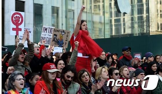 본문 이미지 - 8일(현지시간) 세계 여성의날을 맞아 뉴욕 트럼프타워 인근에서 시위대가 붉은 옷을 입고 '여성이 없는 날' 총파업을 벌였다. ⓒ AFP=뉴스1