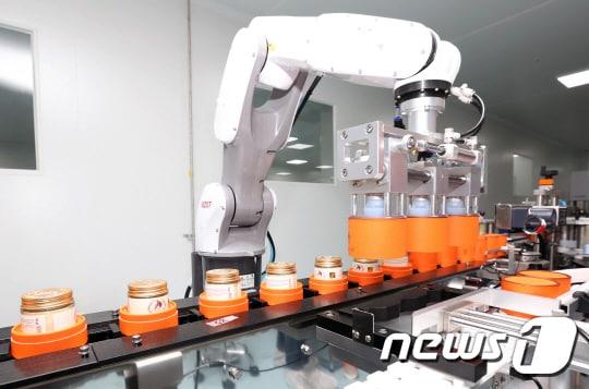 본문 이미지 - 코스나인 에서 화장품 공장에서 자동화로봇이 '게리쏭 9컴플렉스 크림 '을 제조하고 있다.ⓒ News1