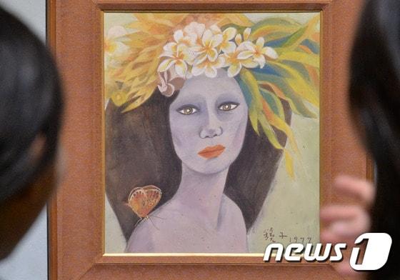 본문 이미지 - 경기도 과천 국립현대미술관에서 관계자가 고&#40;故&#41; 천경자&#40;1924∼2015&#41; 화백의 작품인지를 놓고 논란이 계속되는 &#39;미인도&#39;를 바라보고 있다. 2017.4.18/뉴스1 ⓒ News1 김명섭 기자