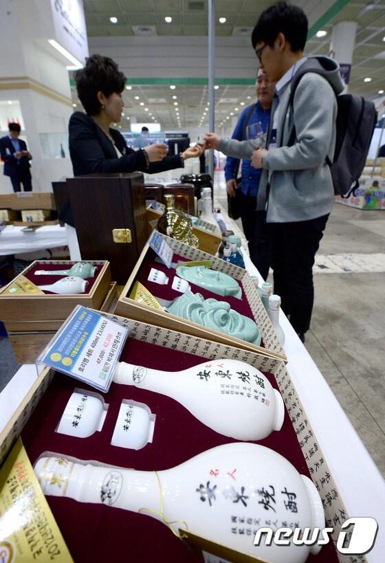본문 이미지 - 27일 오후 서울 강남구 삼성동 코엑스에서 열린 2017 서울국제 와인 & 주류 박람회를 찾은 바이어들이 안동소주를 시음하고 있다. 2017.4.27/뉴스1 ⓒ News1 박정호 기자