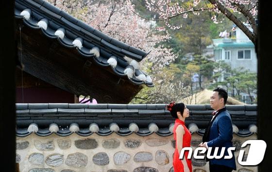 본문 이미지 - 서울 중구 남산골한옥마을에서 외국인 신혼부부가 웨딩 촬영을 하고 있는 모습 ⓒ News1 