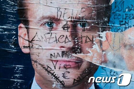 본문 이미지 - 9일(현지시간) 파리에 에마뉘엘 마크롱 프랑스 대통령 당선인의 훼손된 선거 포스터가 보인다. ⓒ AFP=뉴스1 ⓒ News1 우동명 기자