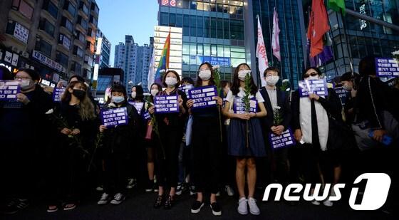 본문 이미지 - 강남역 여성살해사건 1주기인 17일 오후 서울 신논현역을 출발한 범페미네트워크 '우리의 두려움은 용기가 되어 돌아왔다' 추모문화제 참가자들이 강남역 인근 범행장소 앞에서 국화꽃을 들고 피해자를 추모하고 있다. 2017.5.17/뉴스1 ⓒ News1 안은나 기자