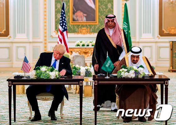 본문 이미지 - 첫 해외 순방에 나선 도널드 트럼프 미국 대통령이 20일(현지시간) 사우디 아라비아 수도 리야드에 있는 대통령궁에서 살만 빈 압둘아지즈 알사우드 사우디 국왕과 함께 약 3500억달러 규모의 투자 계약을 맺었다. 2017.0520ⓒ AFP=뉴스1 ⓒ News1 최종일 기자