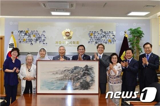 본문 이미지 -  양준욱 서울시의회 의장(왼쪽 5번째)이 19일 의장실에서 이순영 화가(왼쪽 2번째)로부터 '동해'를 기증받고 기념 촬영하고 있다.(서울시의회 제공)/뉴스1 ⓒ News1