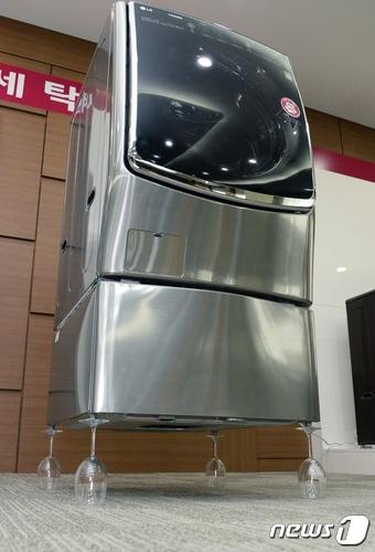 본문 이미지 - LG전자는 지난 5월31일 창원2공장에서 와인잔 위에 트윈워시를 올려놓고 상단 드럼세탁기와 하단 미니워시에서 동시에 탈수를 작동하는 모습을 시연했다. (LG전자 제공) ⓒ News1