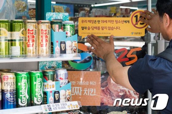 본문 이미지 - 서울 종로구 동숭동의 한 편의점에 청소년 대상 술·담배 판매금지 경고문구 스티커를 부착하고 있다. 서. 2017.6.16/뉴스1 ⓒ News1 유승관 기자