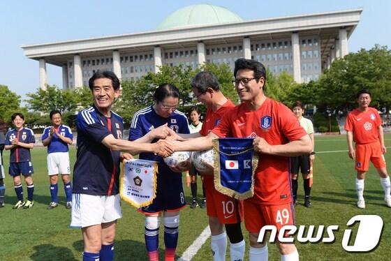 본문 이미지 - 17일 서울 여의도 국회운동장에서 열린 제10회 한·일 국회의원 축구대회에서 양국 의원들이 경기 전 사인볼과 팬던트를 교환하고 있다. 이번 행사는 축구 교류를 통한 양국 의회 간 우호협력을 증진시키기 위해 마련됐다. 2017.6.17/뉴스1 ⓒ News1 오대일 기자