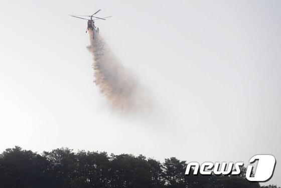 본문 이미지 - 대형 산불이 발생한 서울 노원구 수락산에서 2일 오전 소방헬기가  물을 뿌리고 있다. 전날 밤  발생한 수락산 화재는 이날 오전 2시25분께 잔불을 정리하는 '초진상태'로 돌입했다. 2017.6.2/뉴스1 ⓒ News1 신웅수 기자