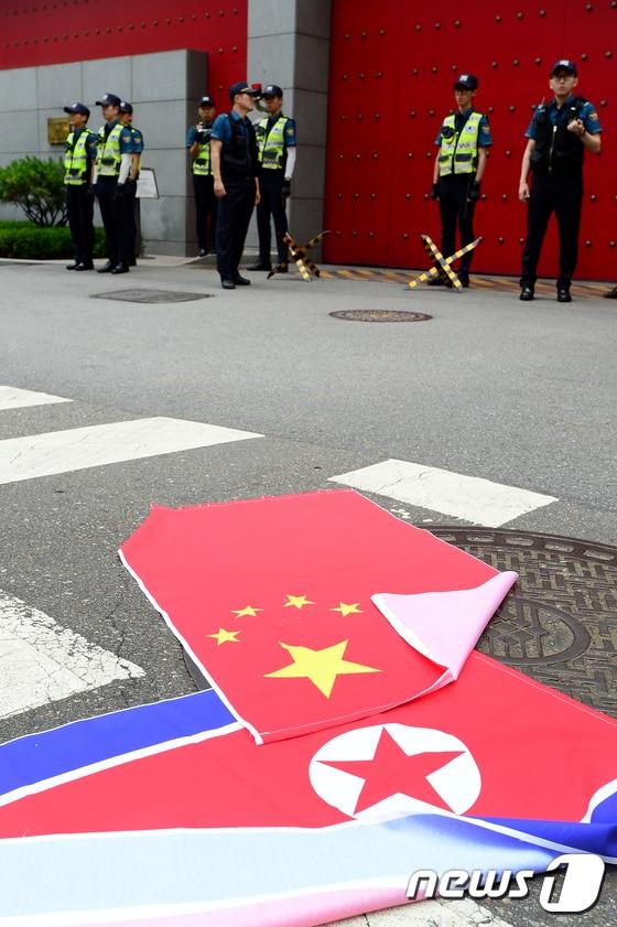 본문 이미지 - 서울 중구의 주한 중국대사관 앞에 오성홍기와 인공기가 바닥에 놓여진 모습./뉴스1 ⓒ News1 임세영 기자