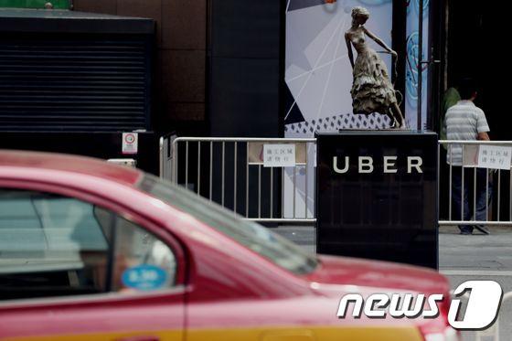 본문 이미지 - 중국 베이징의 한 쇼핑몰 앞에 있는 우버 정거장 앞으로 현지 택시가 지나가고 있다. ⓒ AFP=뉴스1