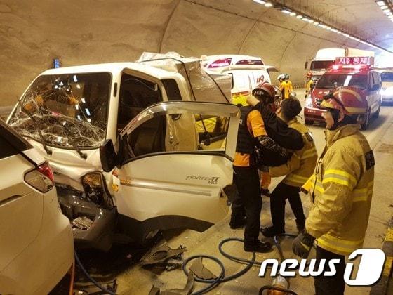 본문 이미지 - 20일 오전 11시3분께 청주~상주 고속도로 상행선 충북 보은군 회인면 회인터널에서 1t포터 화물차가 앞서 가던 카니발 승합차를 들이받아 6중 추돌 사고가 난 뒤 119 구급대가 운전자를 구조하고 있다.(보은소방서 제공).2017.07.20.ⓒ News1