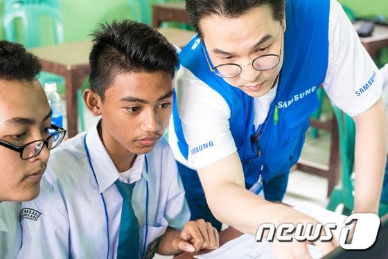 본문 이미지 - 인도네시아 자카르타에 위치한 현지 고등학교에서 삼성전자 임직원이 현지 청소년들을 대상으로 IT 교육을 실시하고 있다. (삼성전자 제공) 