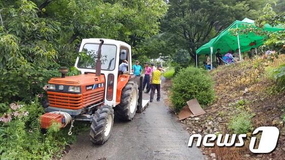 본문 이미지 - 28일부터 주말내내 제천시  학산리  주민들이  누드페션으로  들어가는 진입로를  트랙터로 가로  막고  있다.ⓒ News1
