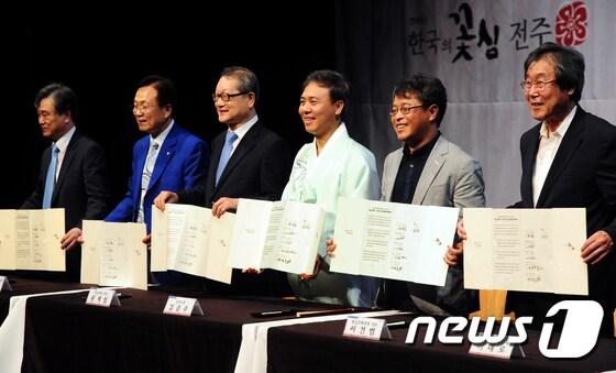 본문 이미지 - 김승수 전주시장이 권재일 한글학회 회장 등 한글단체장들이 6일 전북 전주시 국립무형유산원에서 열린 '전주 완판본체 선포식'에서 업무협약을 하고 있다. 완판본은 조선시대 전주 완산에서 간행된 출판물로 이번 완판본체는 그 당시 완판본에서 글자를 모아 현대한글 11,172자, 영문 및 기호 94자, KS용 기본기호 1,000여자 및 고어체 5,560자로 구성되었다.2017.7.6/뉴스1 ⓒ News1 문요한 기자