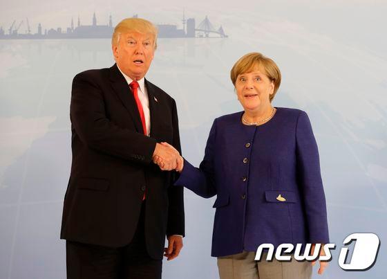 본문 이미지 - 도널드 트럼프 미국 대통령과 앙겔라 메르켈 독일 총리가 6일&#40;현지시간&#41; G20 정상회의가 열리는 독일 함부르크에서 만나 악수를 하고 있다. 2017.07.06ⓒ AFP=뉴스1 ⓒ News1 우동명 기자