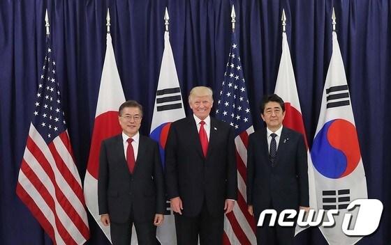 본문 이미지 - 문재인 대통령(왼쪽)과 도널드 트럼프 미국 대통령, 아베 신조 일본 총리가 지난 2017년 7월 독일 함부르크에서 열린 G20 정상회의에 참석하고 있다. (뉴스1 DB)