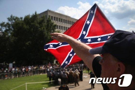 본문 이미지 - 미국 백인우월주의 단체 '쿠클럭스클랜'(KKK) 소속원이 나치식 경례를 하고 있다. ⓒ AFP=뉴스1