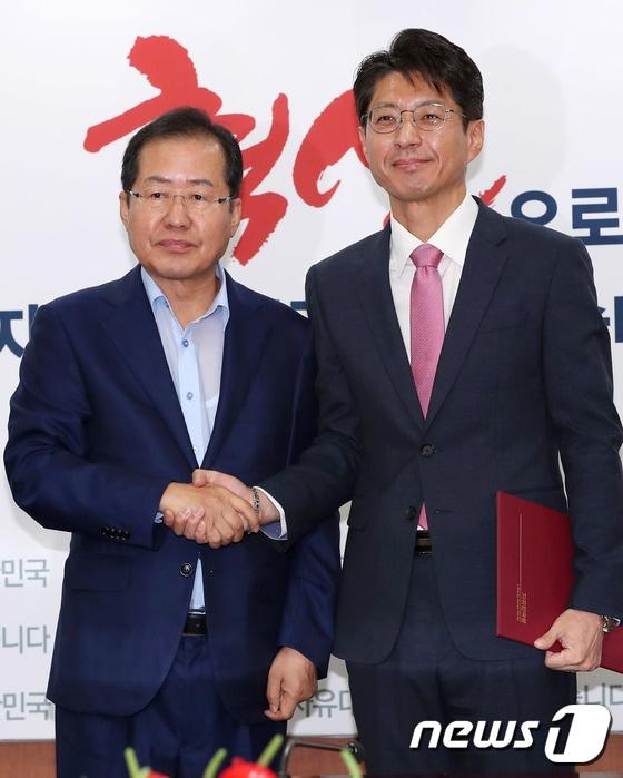 본문 이미지 - 2017년 8월14일 홍준표 당시 자유한국당(현 국민의힘) 대표가 서울 여의도 당사에서 열린 혁신위원ㆍ당대표 특보단 임명장 수여식에서 정장수 공보특보와 기념촬영을 하고 있다. (사진은 기사 내용과 무관함) 2017.8.14/뉴스1 ⓒ News1 DB