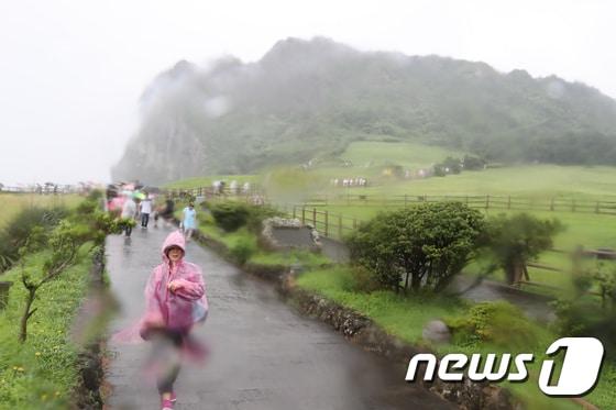 본문 이미지 - 관광객들이 우의를 입고 제주 서귀포시 성산일출봉을 탐방하고 있다. ⓒ News1 