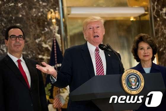 본문 이미지 - 트럼프 대통령이 15일 뉴욕 트럼프타워에서 샬러츠빌 사태 관련 기자회견을 했다. 그 뒤편에는 스티븐 므누신 재무장관과 일레인 차오 교통장관이 자리했다.  ⓒ AFP=뉴스1