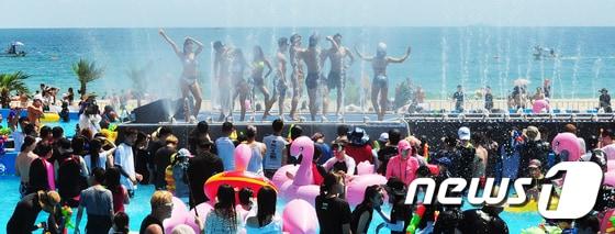 본문 이미지 - 2일 부산 해운대해수욕장에서 열린 부산바다축제 '물의 난장'에 참가한 피서객들이 수영복을 입고 무대에 오른 휘트니스 트레이너들을 보며 물총놀이를 하고 있다. 2017.8.2/뉴스1 ⓒ News1 여주연 기자