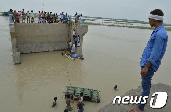 본문 이미지 - 계절풍(몬순)의 영향으로 대규모 홍수가 발생한 인도에서 18일 피해주민들이 구조작업을 진행하는 모습. ⓒ AFP=뉴스1